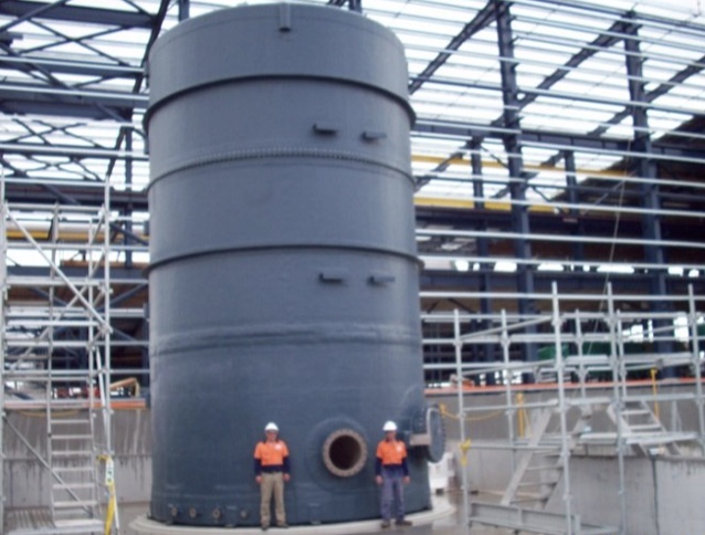 Two RGE crew beside a large grey FRP tank on site